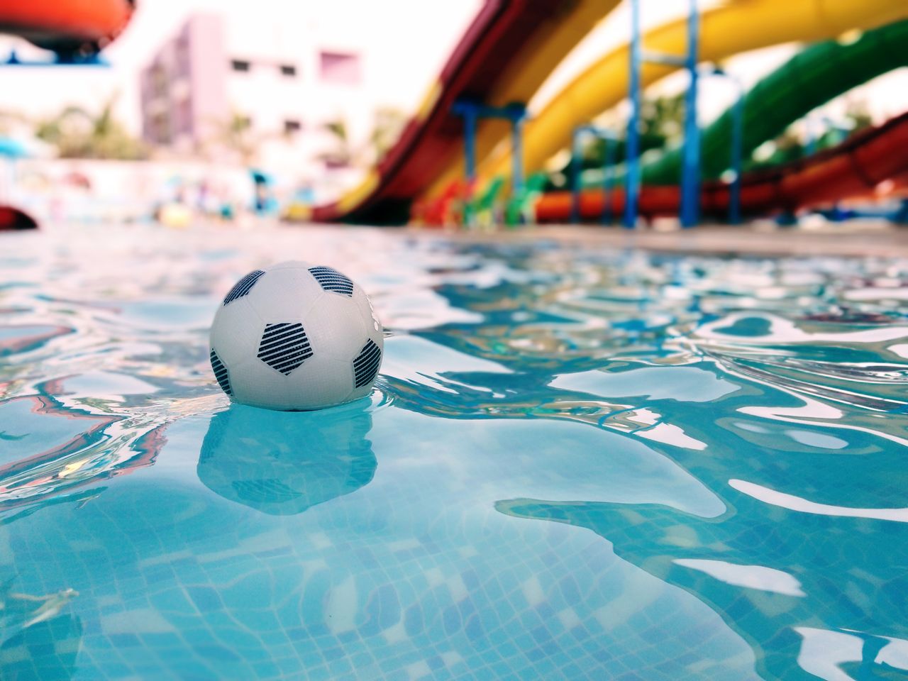 Bal in het zwembad voor de kleurrijke glijbanen van het waterpark