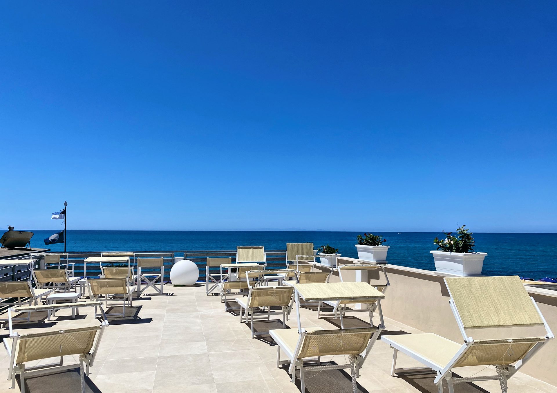 Terrasse mit Meerblick im Hotel Cecina Beach mit Liegen und Tischen